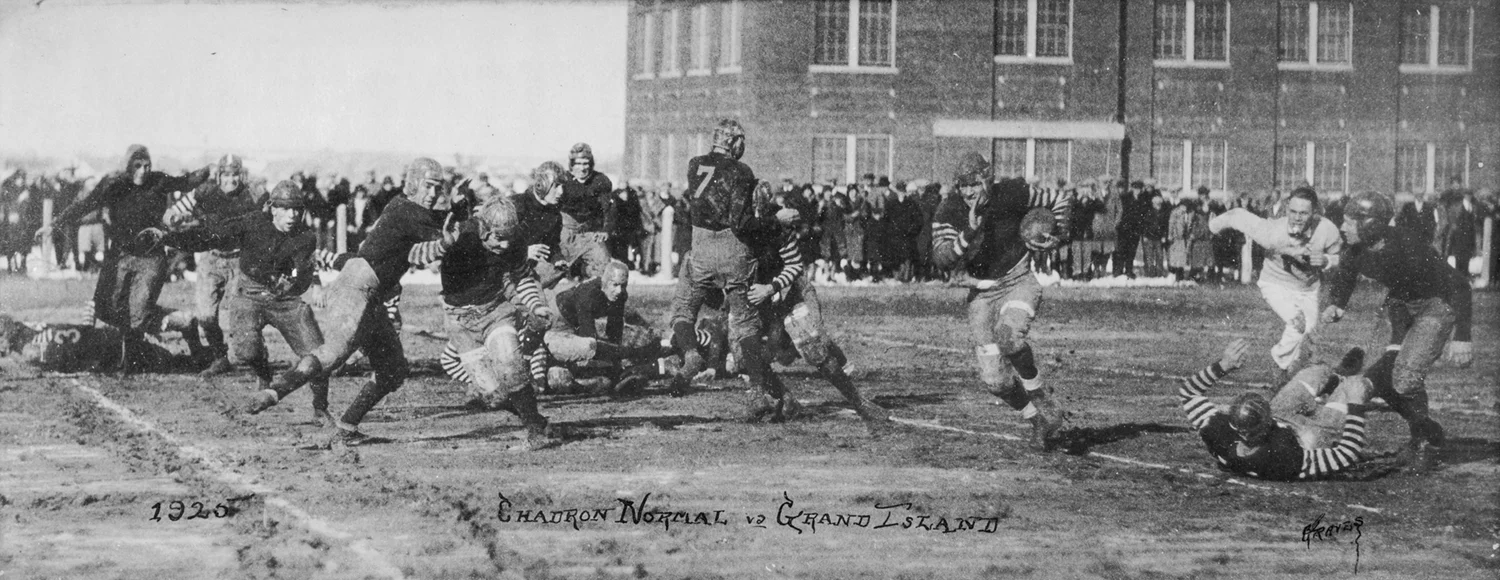 Football player running the ball, surrounded by offense and defense