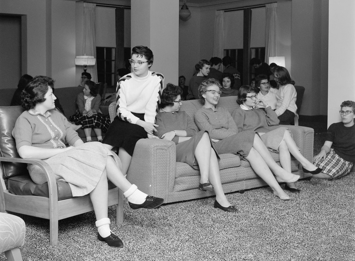 Students relaxing on sofa and chairs in a residence hall