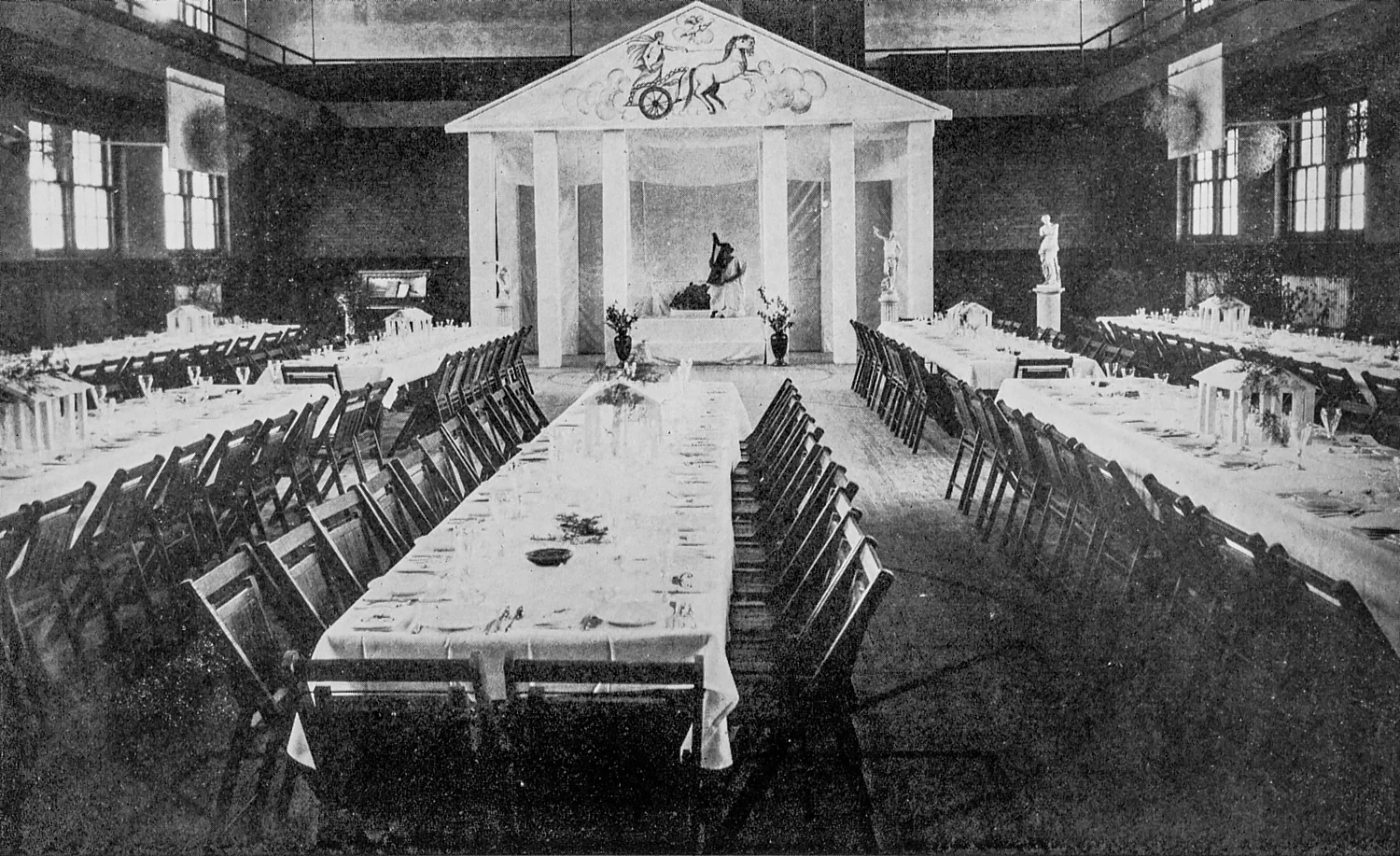 Formal dinner tables set up in a gymnasium