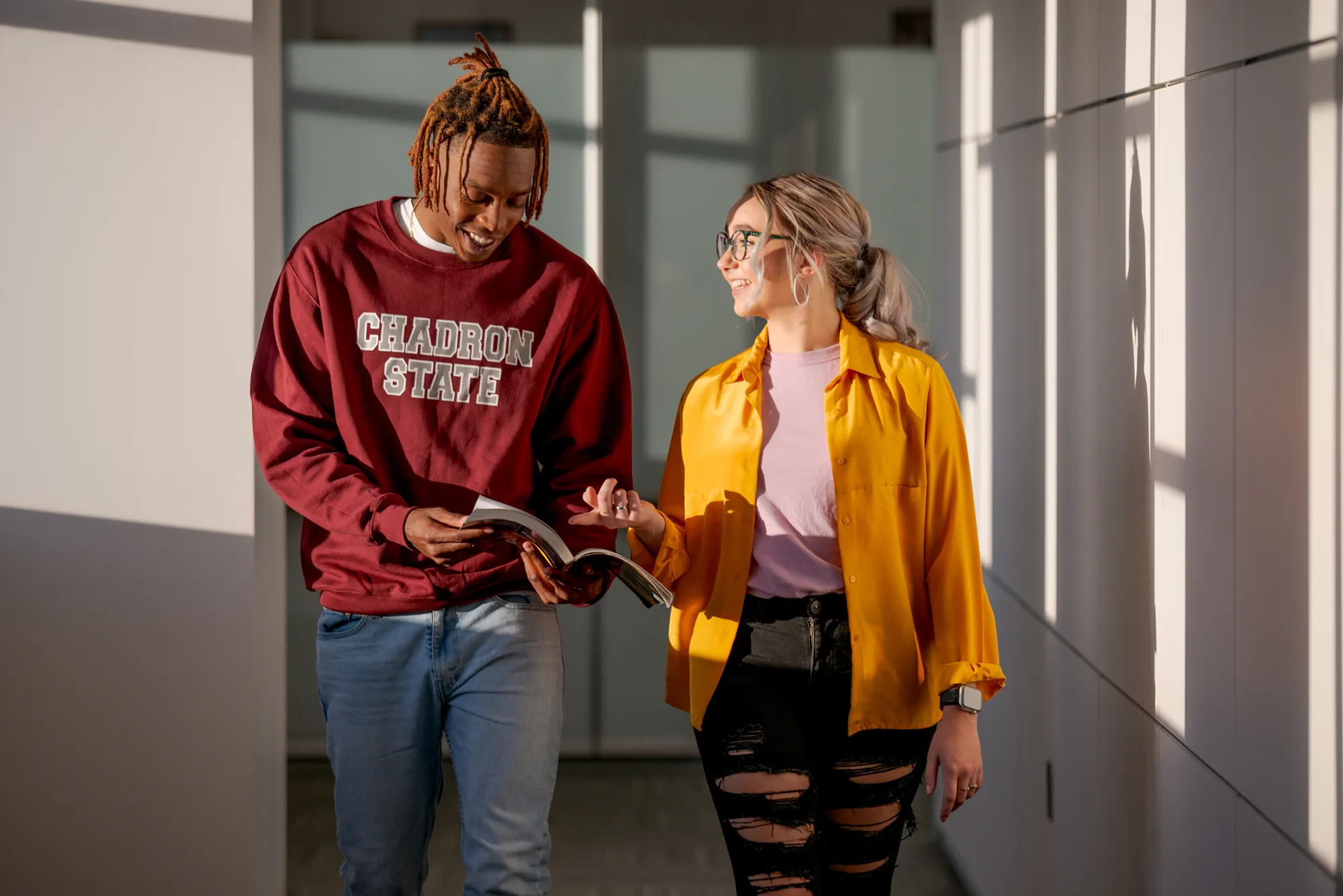 Two students walking and talking on campus