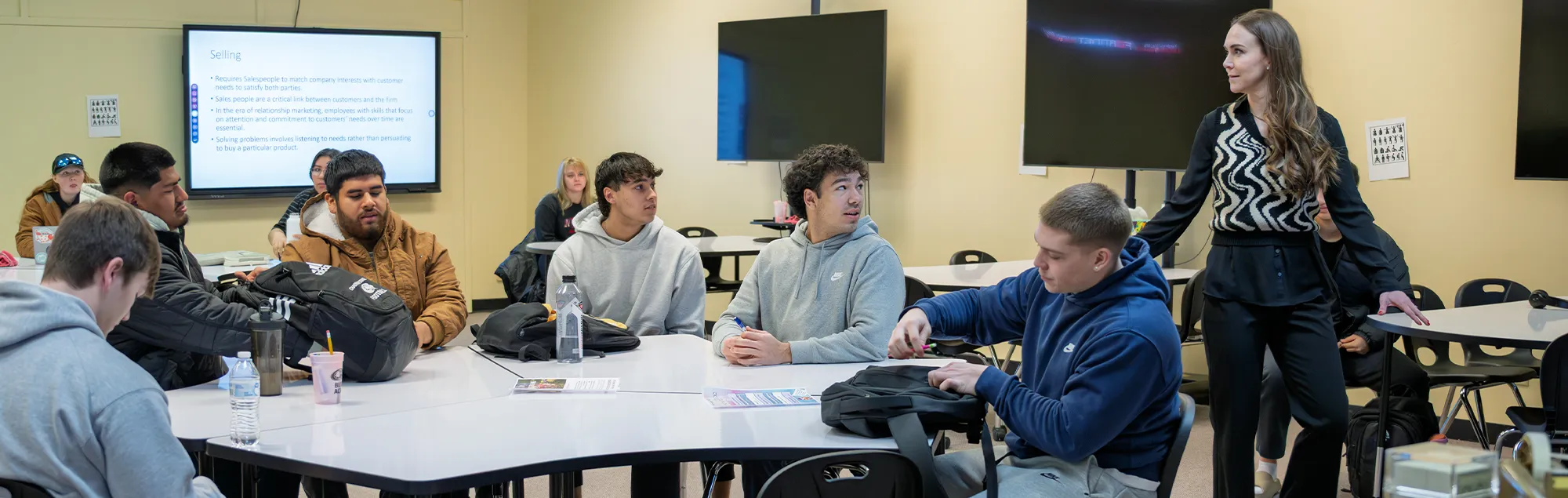 Several students engaged in discussion with a Business professor