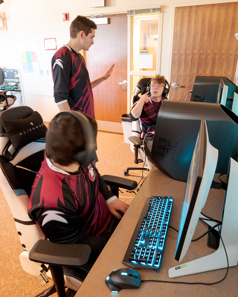 Esports coach speaking to two students