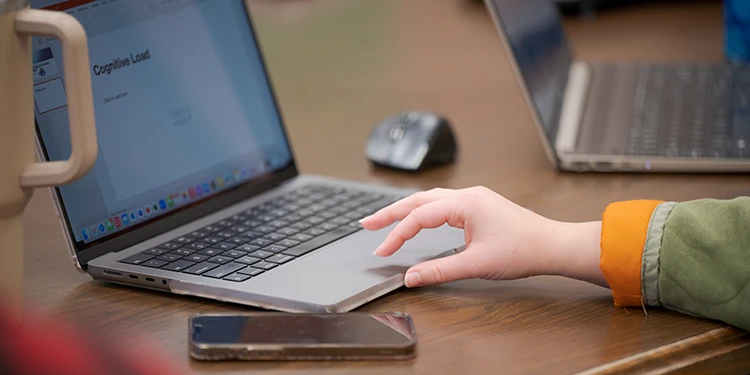 A close up of a hand using a laptop