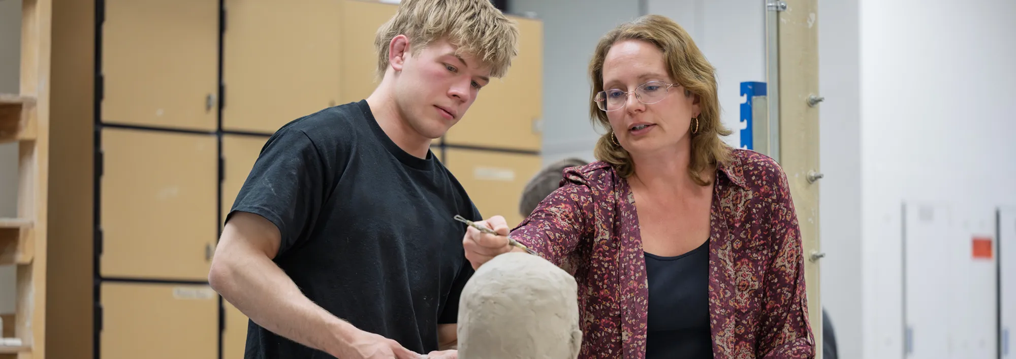 Art student and professor discussing a sculpture project