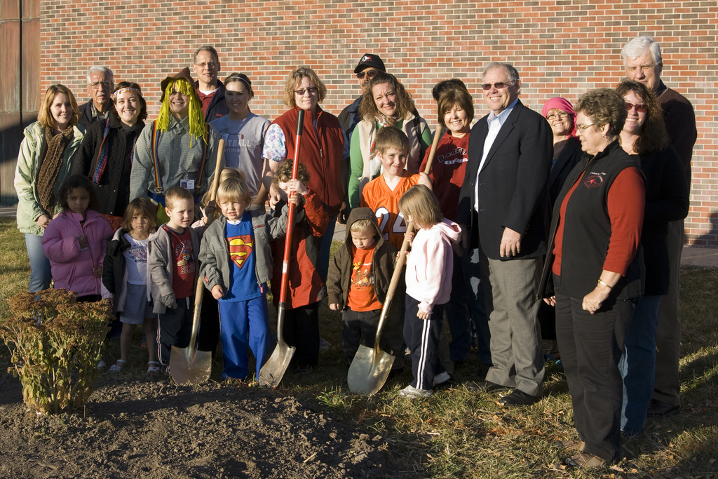 Adults and kids pose with shovels