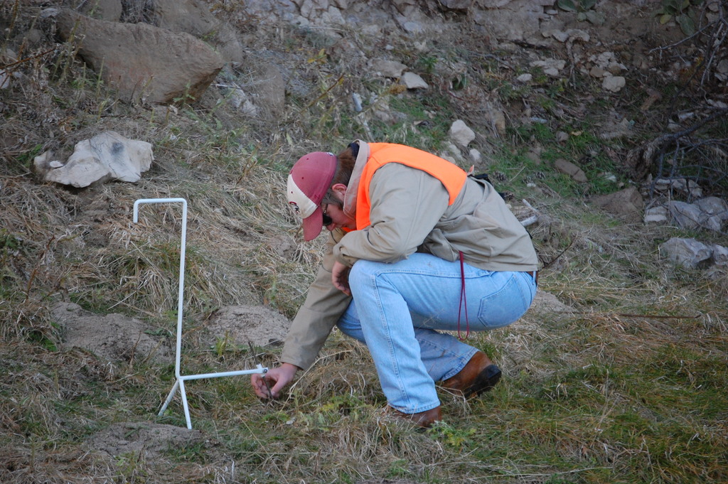 Austin Horn, junior, of Sidney, uses a modified-step-point device to collect range data about soil cover and species composition.