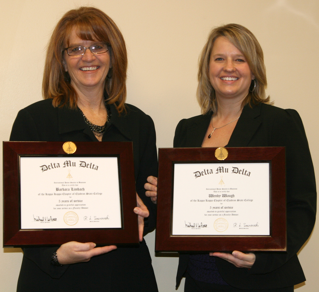 Dr. Barbara Limbach and Dr. Wendy Waugh display the service awards they received during the induction ceremony.