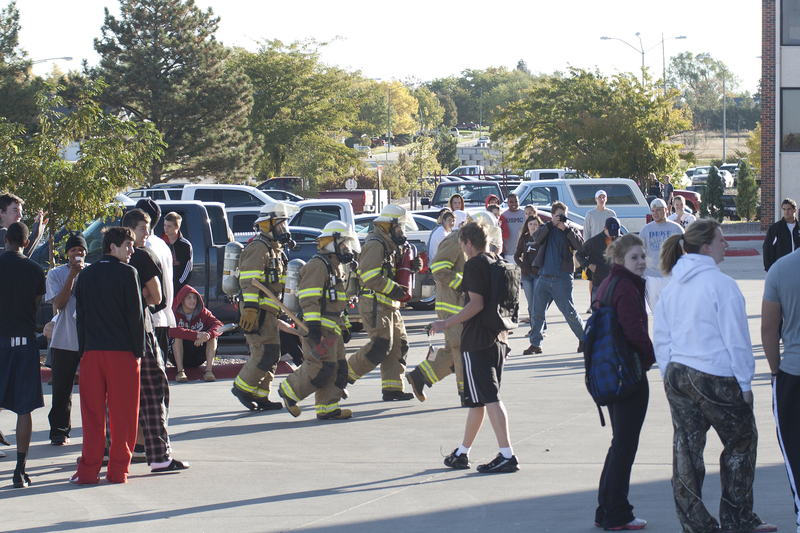 Firefighters enter the Chadron State College High Rise Residence Hall on Friday, as students wait out the incident.