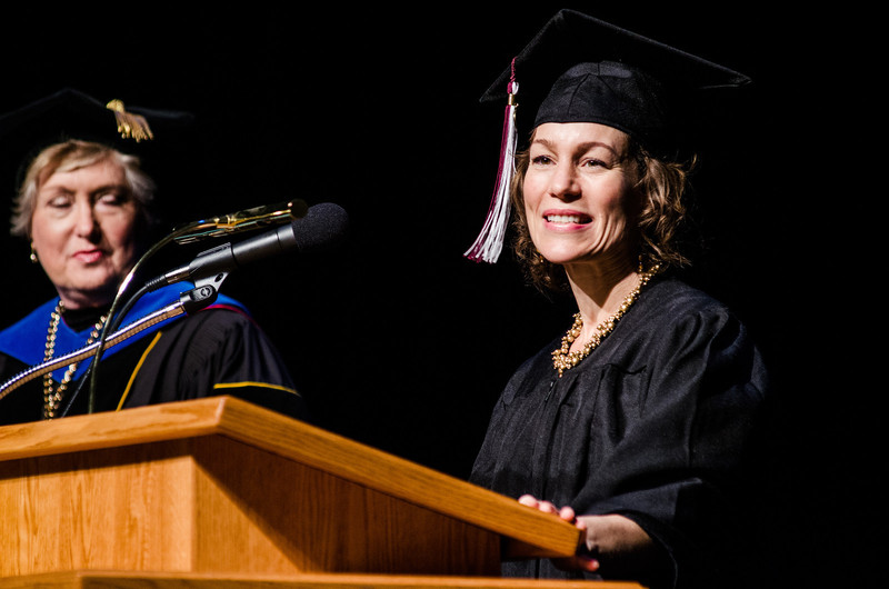 Leslie Caswell helps open the ceremony for master's degree recipients with a