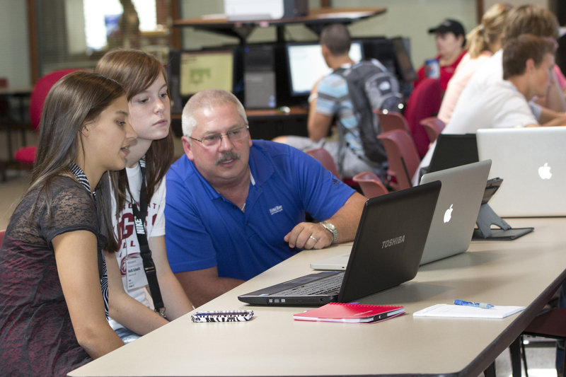 Chadron State College students Holly Schmitz and Emily Hollopeter of Valentine receive assistance in getting connected from Dolyn Brown, CSC information technology network administrator, Aug. 17