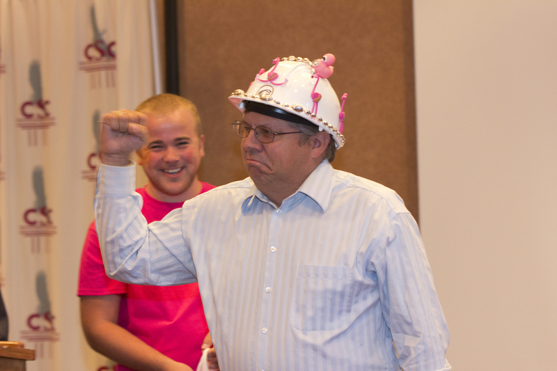 Dale Grant, Chadron State College vice president for administration and finance, pumps his arm after being presented a hard hat by CSC student Luke Wright of Hamlet during the fall semester's first meeting of the faculty and staff Aug. 17