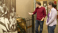 Two students look at a pair of moccasins