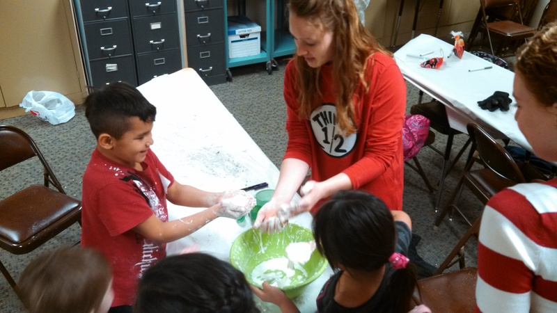Chadron State College education major Tess Jones, Riverton, Wyo., helps a group of students mix up a batch of Oobleck after reading 