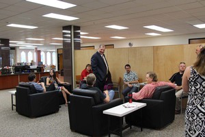 Dr. Randy Rhine, CSC president, standing, visits with faculty and staff at the opening of the coffee shop in the Library Learning Commons.