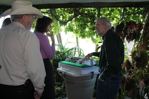 Russ Finch uses a model to explain his new greenhouse design.