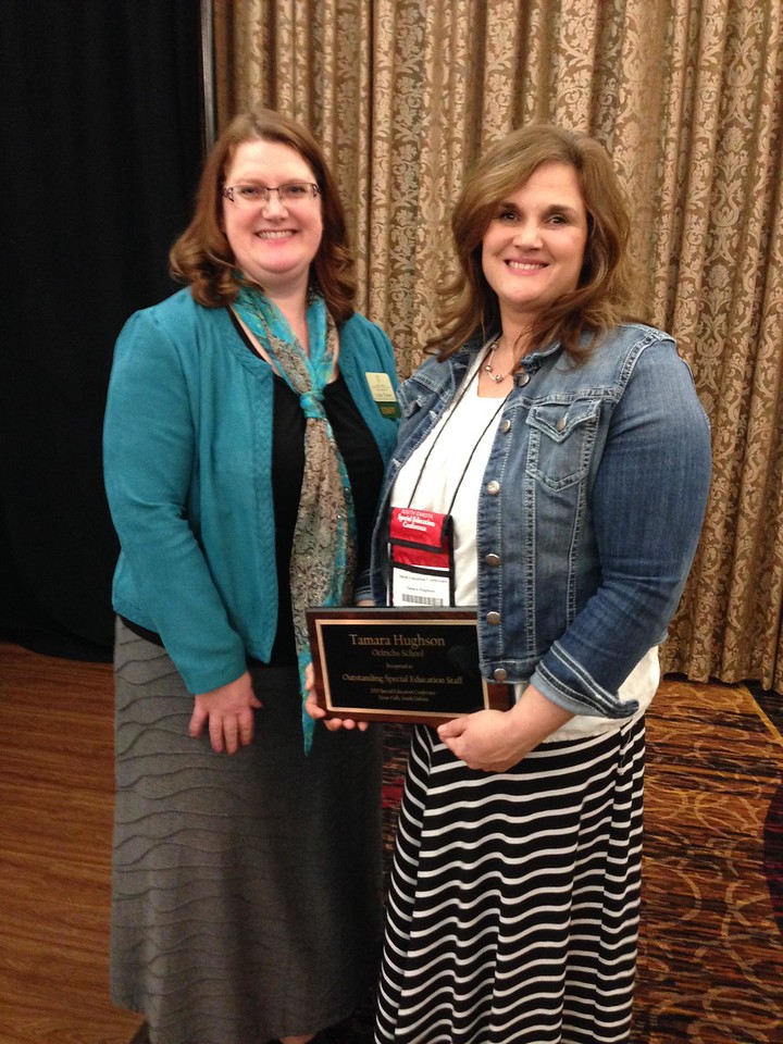 Two women posing with an award