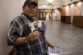 Darrell Marshall poses with photos of person who made his quilt