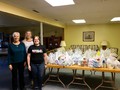 Volunteers pose with food from food drive