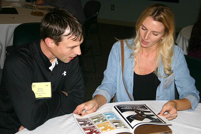 Chadron State College graphic design student Caitlyn Wiseman of Chadron, Neb., right, shows her portfolio to Chris Johnson, an advertising professional, during the American Advertising Federation's Meet the Pros event in Omaha Feb. 20-21, 2017.