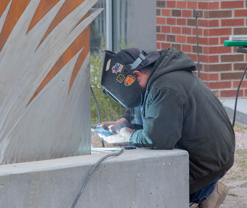 A welder with Couty Design Build of New Mexico welds the