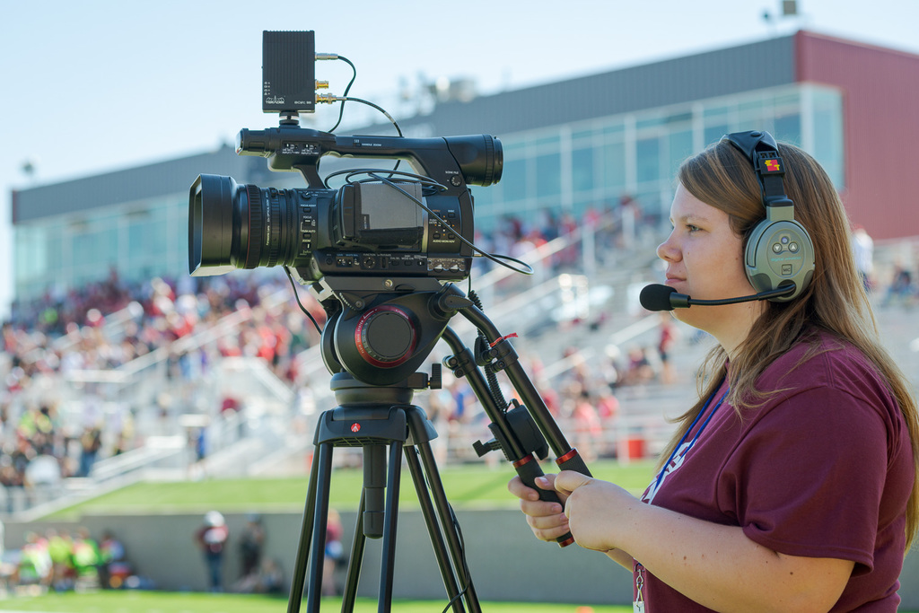 Kayla Reinke operates an end zone camera during a football game.