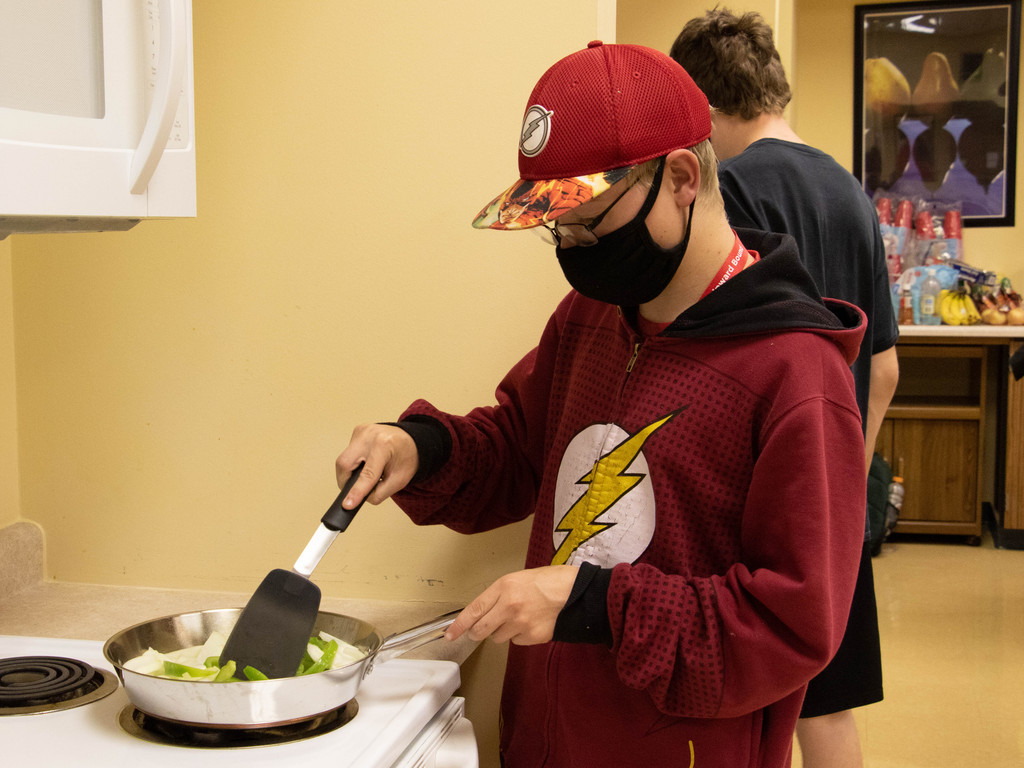 Quinten Hallsted of Chadron sautes onions and green peppers in a Upward Bound Summer Program cooking class