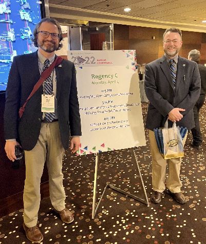 Alex Helmbrecht and Daniel Binkard at a National Conference Presentation standing next to a whiteboard