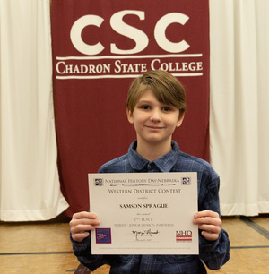 One high school student poses with his award as CSC hosts History Day