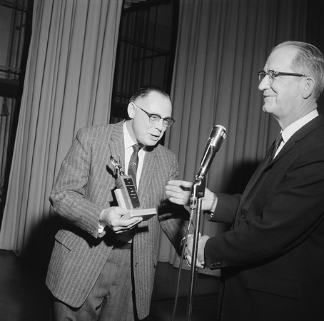Adult male presenting a trophy to another male