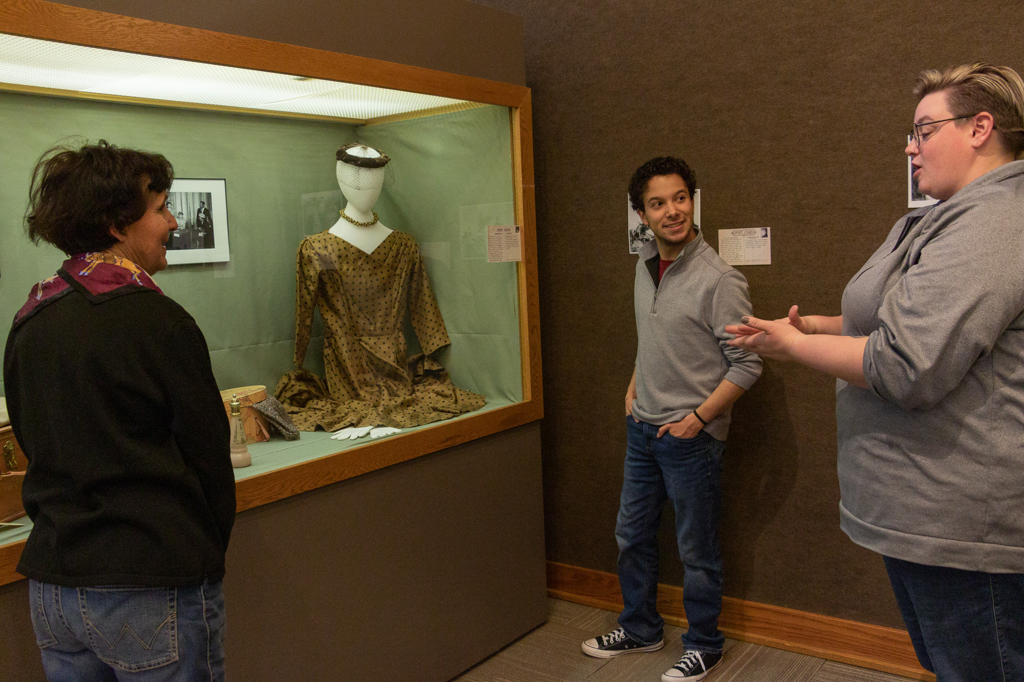 Three people talking at a museum display