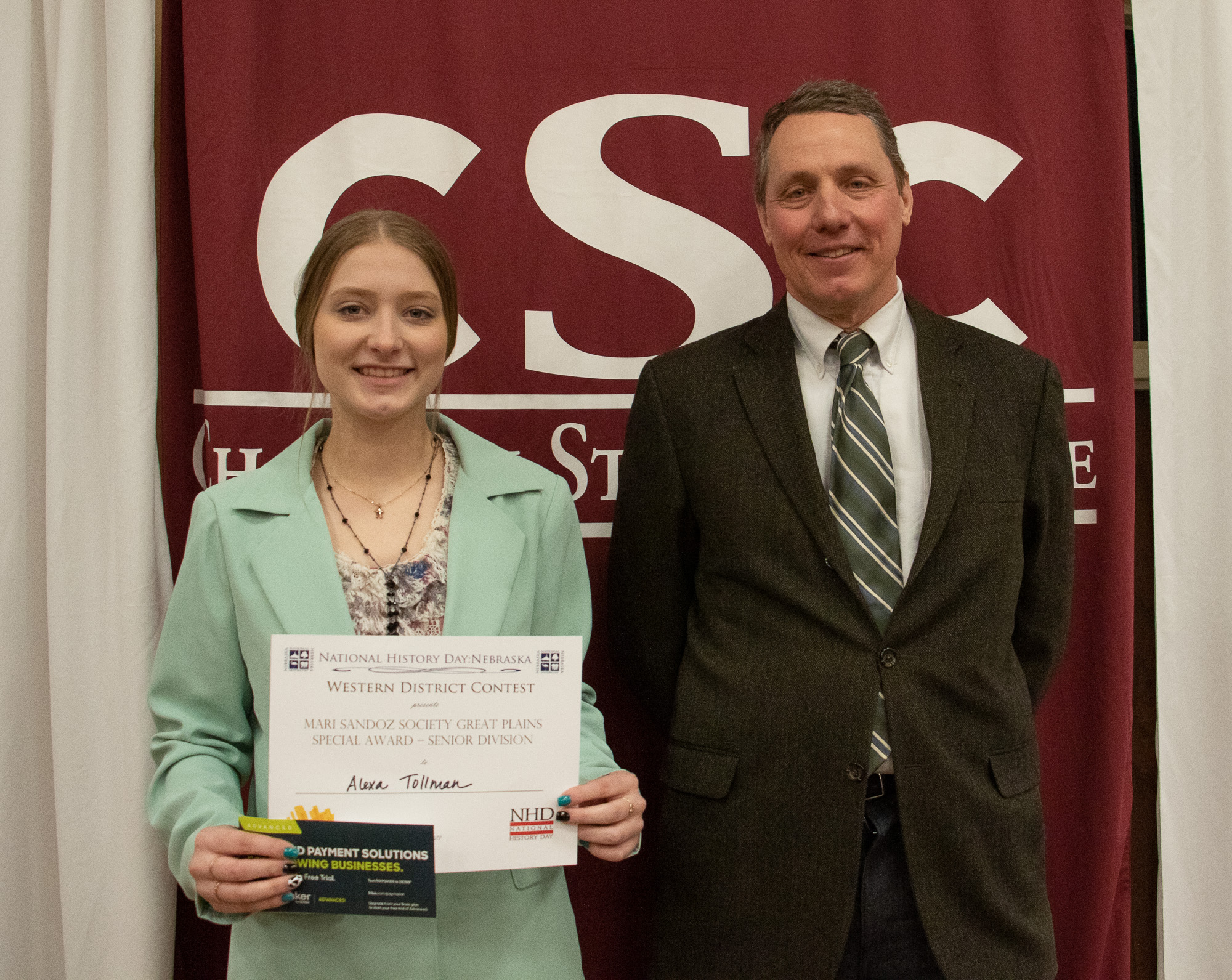 A student and a professor pose with an award