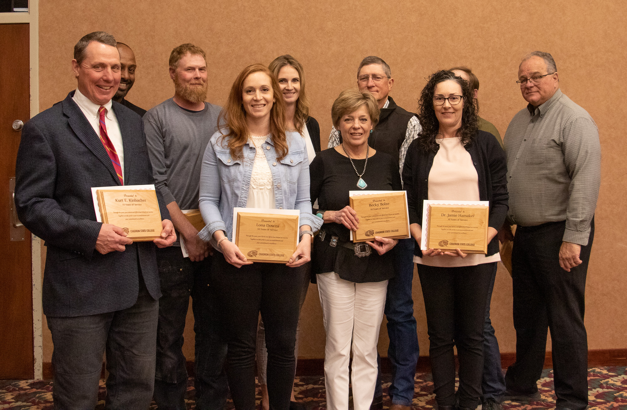 A group posing with awards