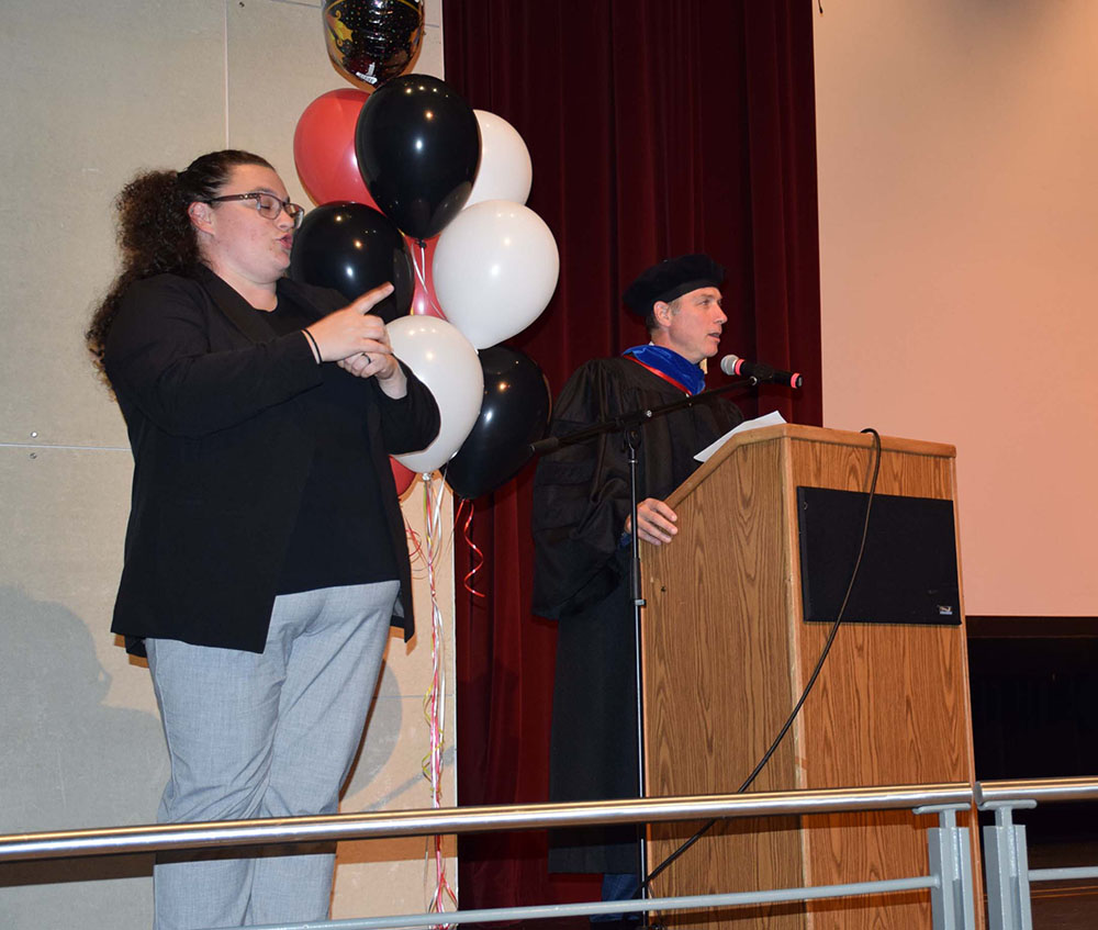 Speaker at a podium and sign language interpreter on a stage