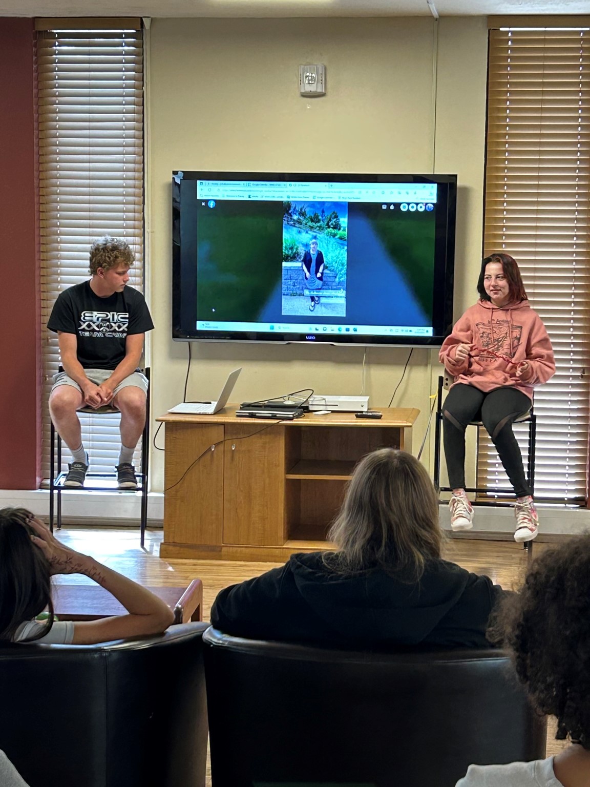 Two students making a presentation on a screen