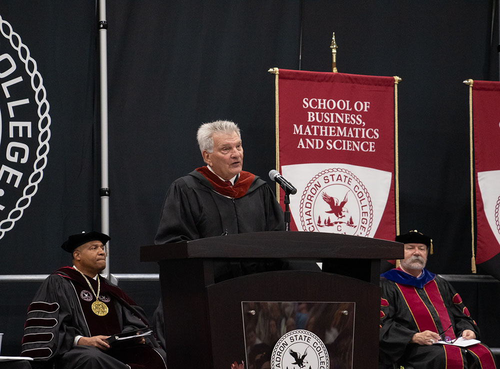 Male speaking at a podium on a stage