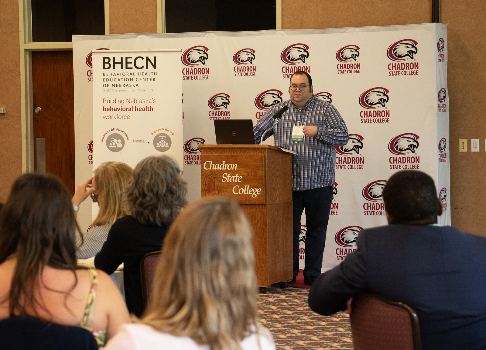 Man speaking to an audience at a podium