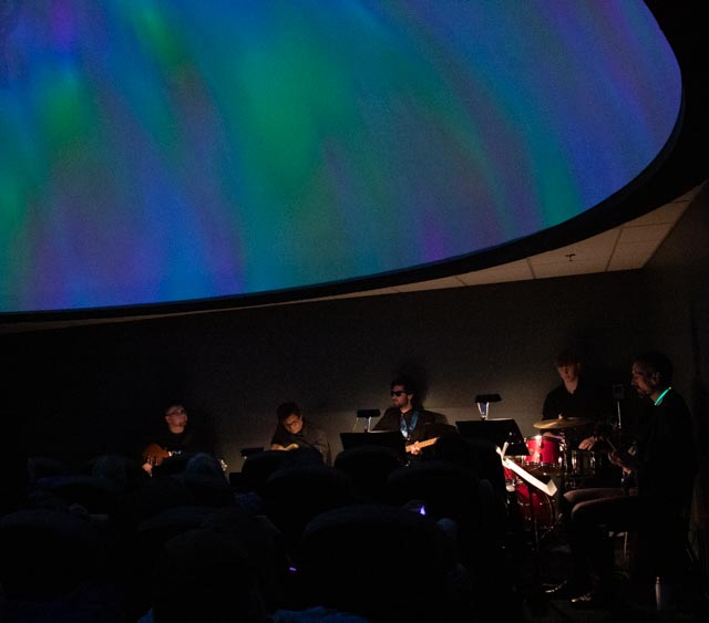 Musicians playing in a planetarium