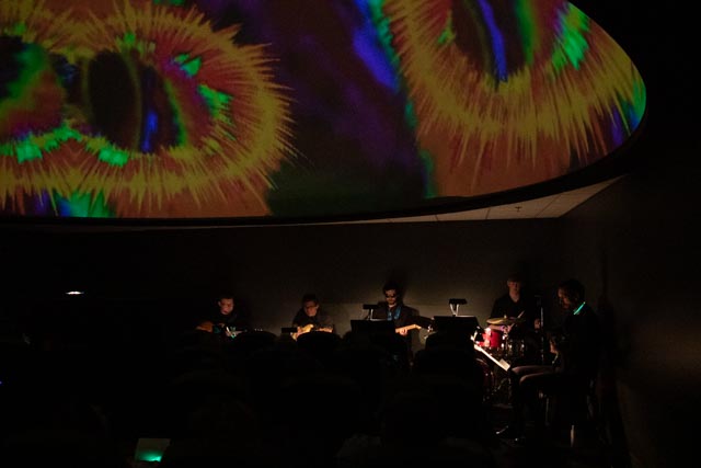 Musicians performing in a planetarium