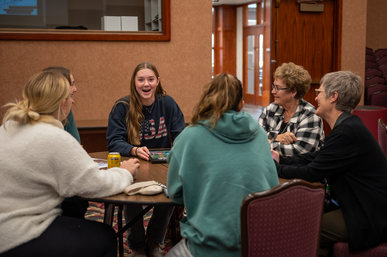 Students and employees talking around a table