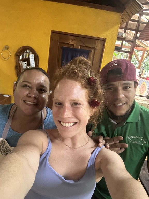 Woman taking a selfie with two other workers in a kitchen