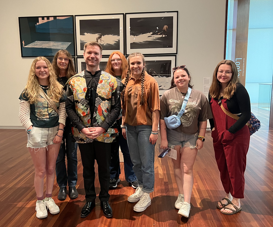 A group of adults pose in an art museum
