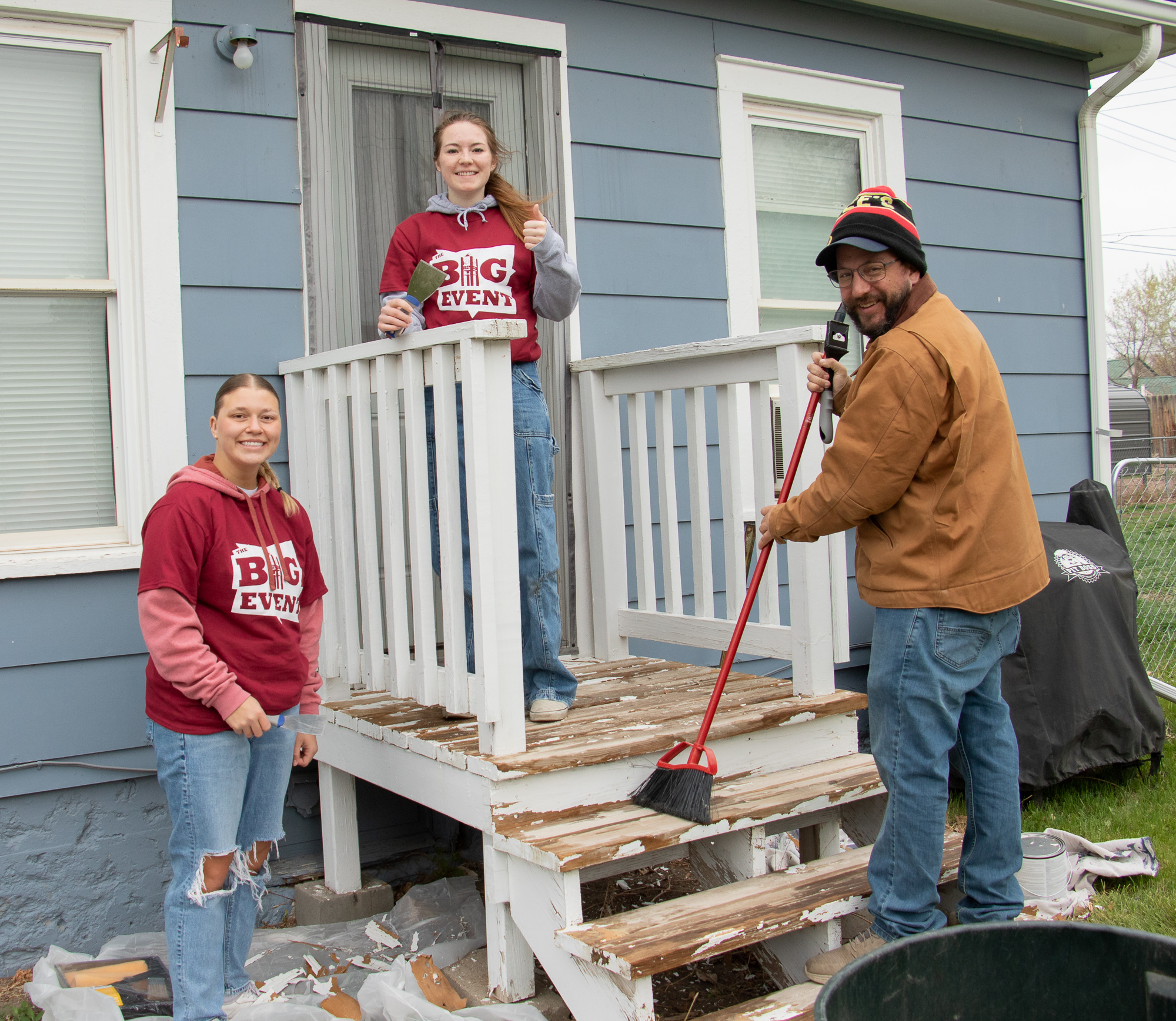 Three adults painting outside