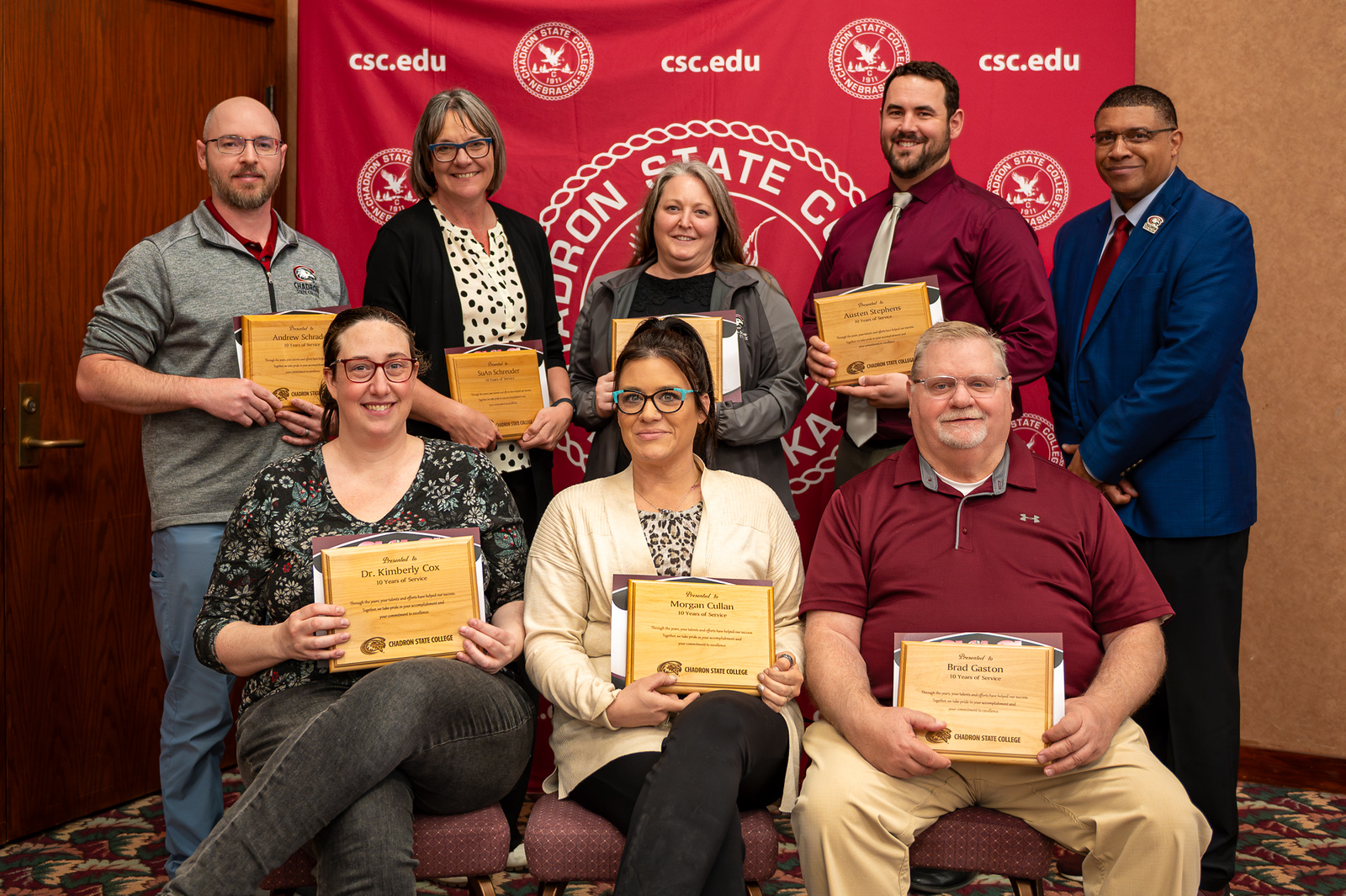 A group of adults posing with awards