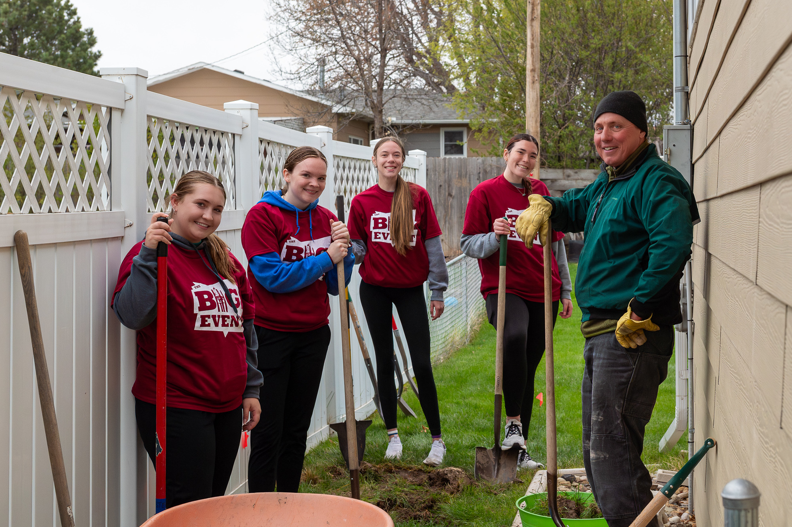 Group of adults popsing outside while doing yard work
