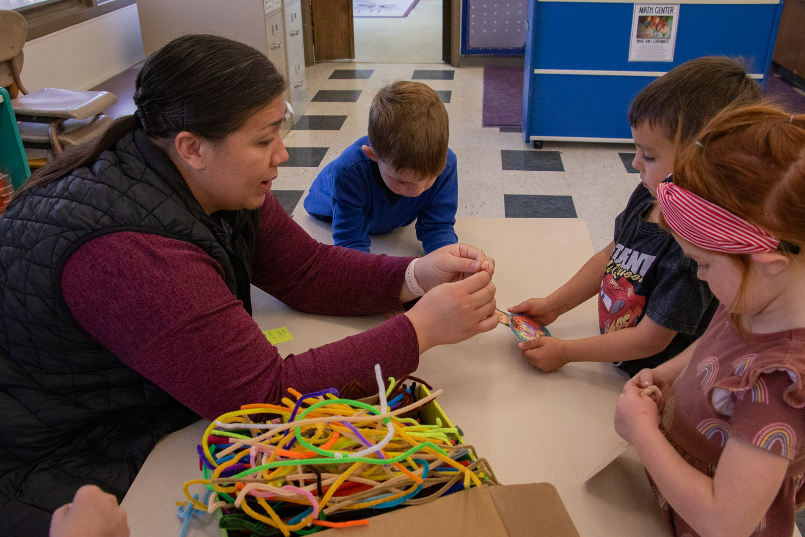Teacher and children work together on a craft