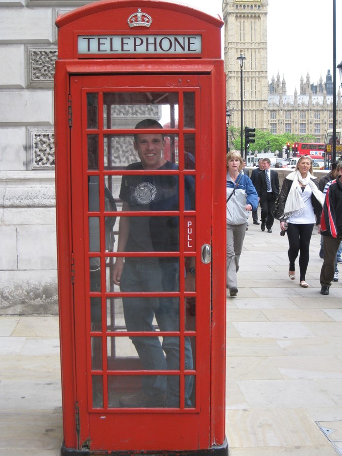 Student posing in a phone booth in London