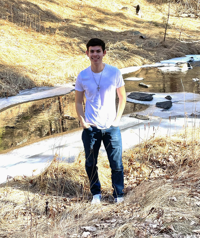 Student posing by a creek