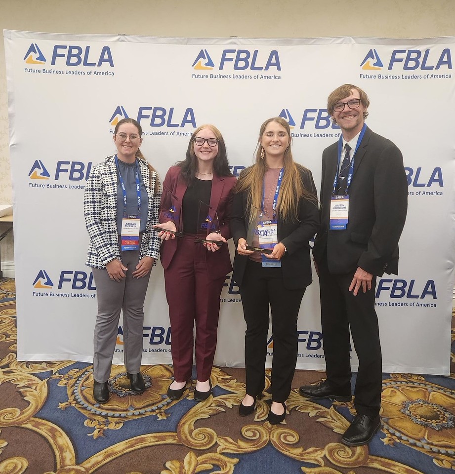 Four students posing with awards