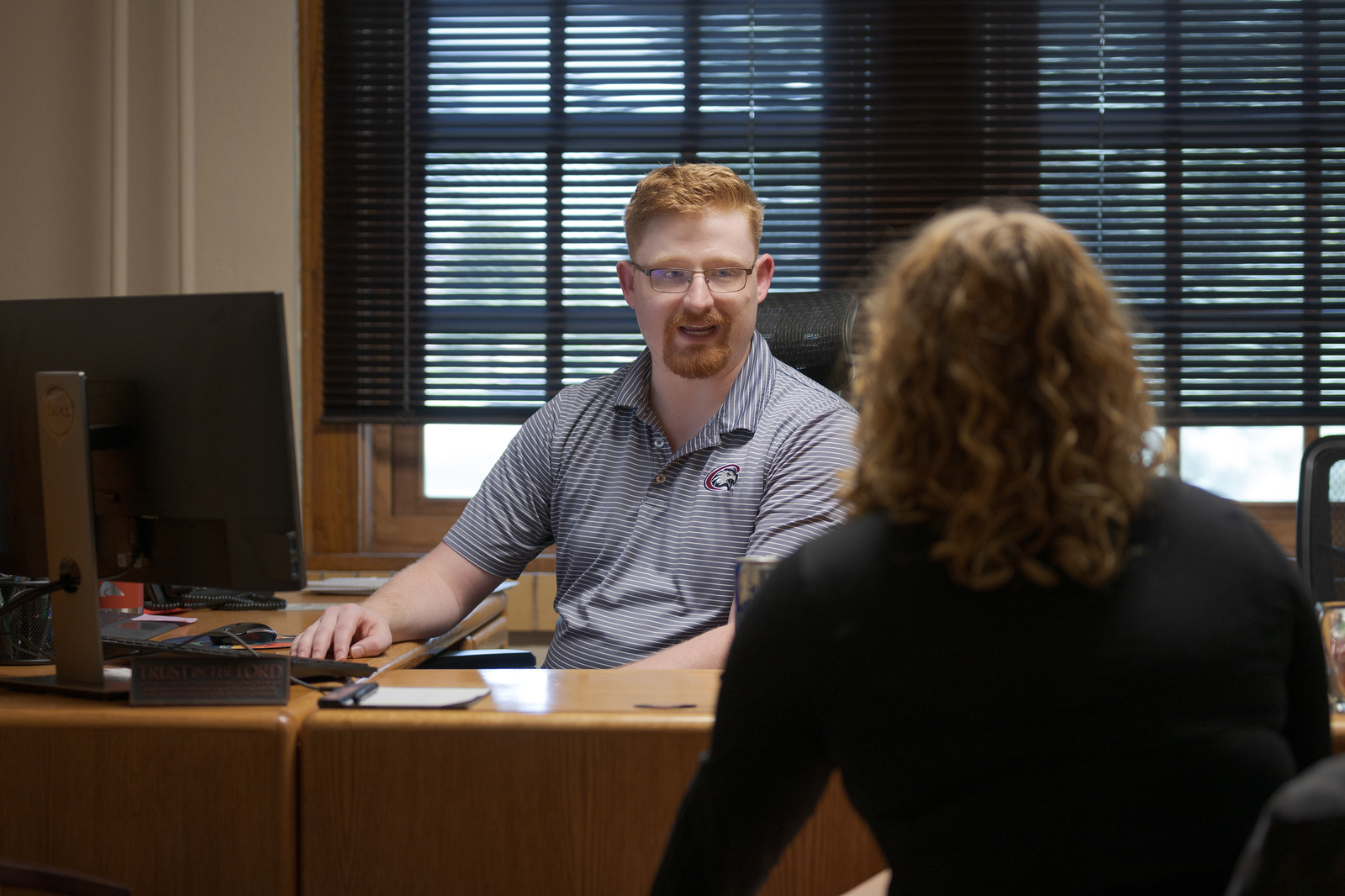 Staff person at a desk helping a student