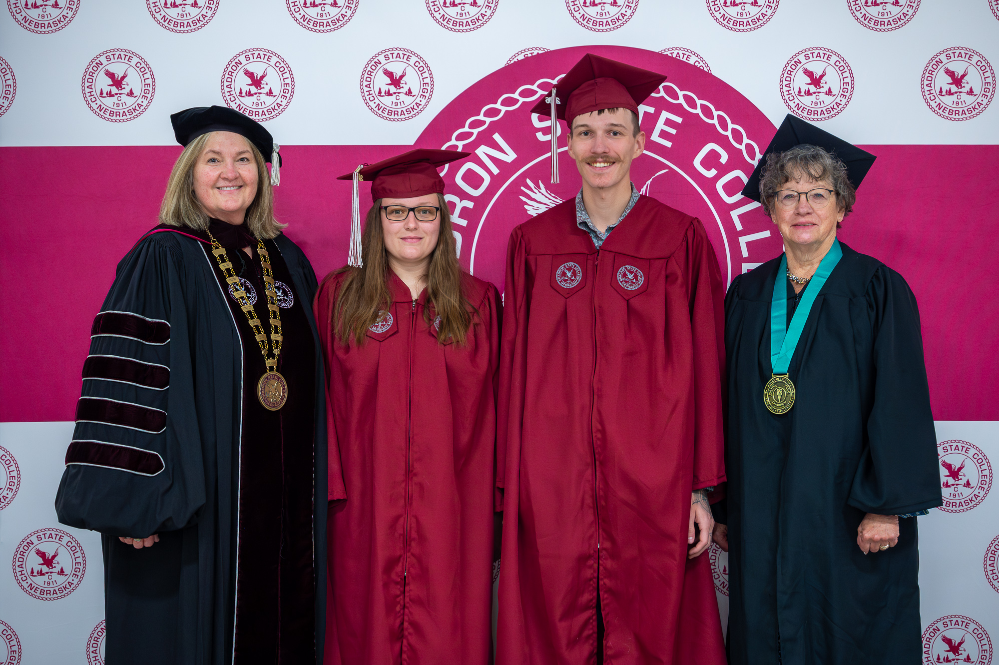 Four adults posing at Commencement